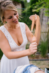 Bruid laat custom made bretellen zien voor de bruidskinderen door spontane fotografie Antwerpen Hilde Hoebers